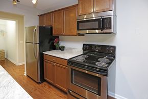 Burnsville apartment for rent - A kitchen with a black stove top oven and a black microwave above it.