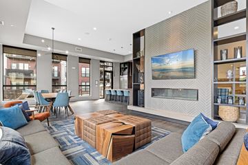 New Hope apartment for rent - A modern living room with a grey sofa, a wooden coffee table, and a large painting on the wall.