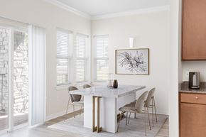Loveland townhouse for rent - a dining room with a white table and chairs and a painting on the wall