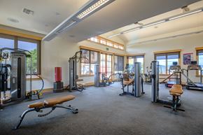 Loveland townhouse for rent - a large fitness room with exercise equipment and windows