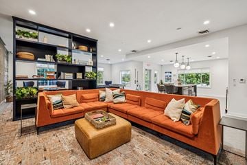 Lincoln apartment for rent - A living room with a large orange sofa and a coffee table in front of a bookshelf.