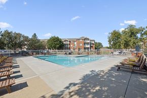 Lincoln apartment for rent - A large swimming pool surrounded by sun loungers and trees.