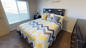 Bismarck apartment for rent - a bedroom with a yellow and gray comforter on a bed