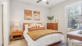 Denver apartment for rent - A bedroom with a bed, nightstand, and a ceiling fan.