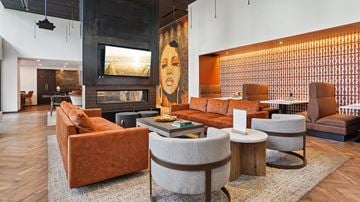 Denver apartment for rent - A living room with a fireplace and a painting of a woman on the wall.