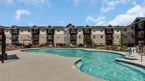 Monticello apartment for rent - a swimming pool with an apartment building in the background