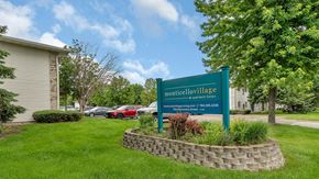 Monticello apartment for rent - a sign sits in the grass in front of a building