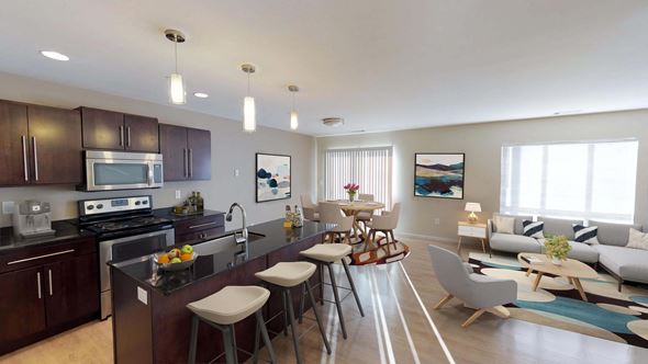 Bismarck apartment for rent - Open kitchen and living area with a large window and door to balcony or patio. Kitchen has dark wood cabinetry and large island for entertaining.