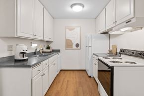 Plymouth apartment for rent - A kitchen with white cabinets and a wooden floor.