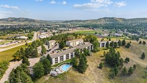 Rapid City apartment for rent - an aerial view of a building with trees and a city in the background