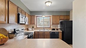 Billings apartment for rent - a kitchen with black appliances and wooden cabinets