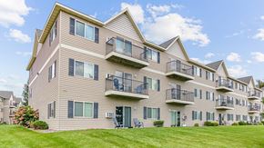 Isanti apartment for rent - the view of an apartment building with balconies and a lawn