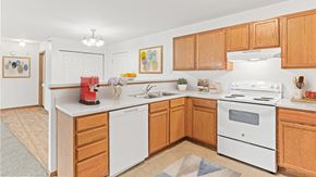 Isanti apartment for rent - a kitchen with white appliances and wooden cabinets