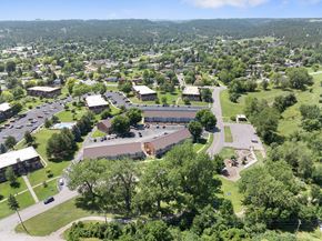 Rapid City apartment for rent - A large building complex with a parking lot in front of it.
