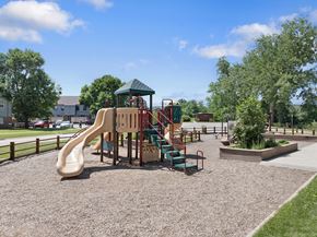Rapid City apartment for rent - A playground with a slide, swings, and a green roofed structure.