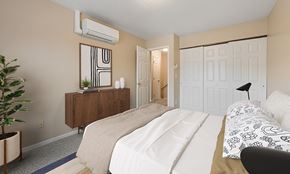 Rapid City apartment for rent - A bedroom with a large bed and a wooden dresser.