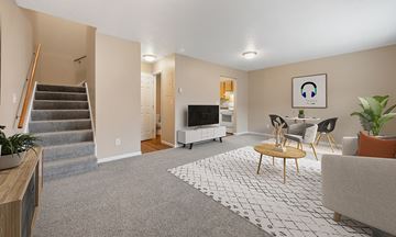 Rapid City apartment for rent - A living room with a grey carpet and a white rug with a black and white pattern.