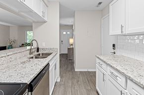 Lakeville townhouse for rent - A kitchen with white cabinets and granite countertops.