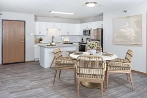 Rochester apartment for rent - a dining area with a table and chairs and a kitchen in the background