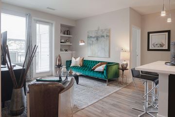Denver apartment for rent - a living room with a green couch and a dining room table