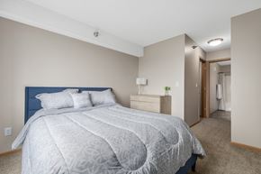 Rochester apartment for rent - A bedroom with a large bed and a carpeted floor.