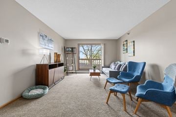 Rochester apartment for rent - A living room with a blue chair and a grey couch.