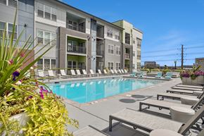 Denver apartment for rent - A pool area with sun loungers and a building in the background.