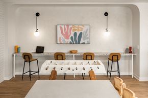 Minneapolis apartment for rent - a meeting room with a long table with chairs around it and two lamps hanging from the ceiling
