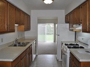 Mishawaka townhouse for rent - a kitchen with a white refrigerator freezer next to a stove top oven
