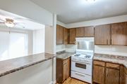 Morris apartment for rent - A kitchen with a stove top oven and wooden cabinets.