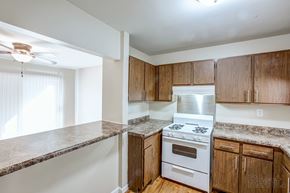 Morris apartment for rent - A kitchen with a stove top oven and wooden cabinets.