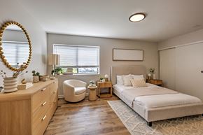 Mishawaka apartment for rent - A well-lit bedroom with a large bed and a chair.