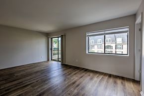 Mishawaka apartment for rent - A room with wooden floors and a window showing a view of buildings outside.