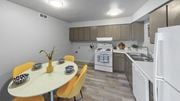 Trotwood apartment for rent - a kitchen with white appliances and a table with yellow chairs