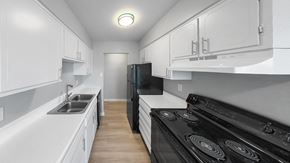 Indianapolis apartment for rent - a kitchen with white cabinets and black appliances and a sink