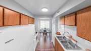Indianapolis apartment for rent - a kitchen with wooden cabinets and a sink and a dining room with a table