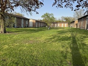 Elkhart apartment for rent - A grassy field with a building in the background.