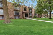 Matteson apartment for rent - exterior view of a brick apartment building with green grass and trees