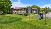 Goshen apartment for rent - A playground with a slide and a ladder is in front of a building.