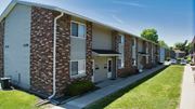 Goshen apartment for rent - A row of brick apartment buildings with garage doors.