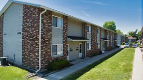 Goshen apartment for rent - A row of brick apartment buildings with garage doors.
