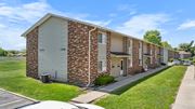 Goshen apartment for rent - A row of brick apartment buildings with garage doors.
