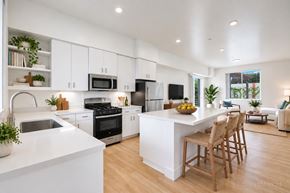 Santa Barbara apartment for rent - A modern kitchen with white cabinets and a large island.