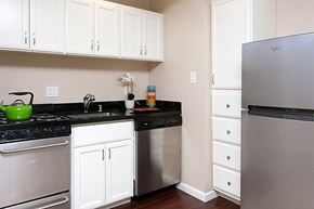 Burlingame apartment for rent - A kitchen with white cabinets and a black countertop.