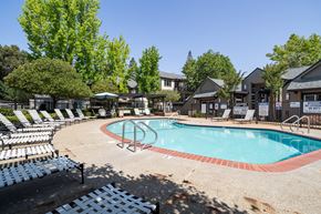 Concord apartment for rent - A pool surrounded by chairs and trees.