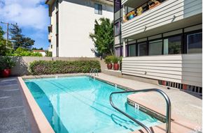 Burlingame apartment for rent - A small pool with a metal ladder sits in front of a building.