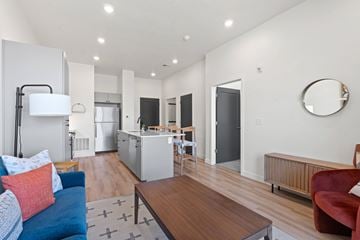 American Fork apartment for rent - A modern living room with a blue couch and a wooden coffee table.
