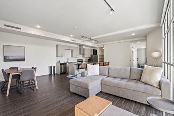 A modern living room with a grey couch and a wooden coffee table.