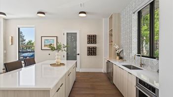 A modern kitchen with a white countertop and wooden cabinets.