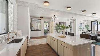 A modern kitchen with a white countertop and wooden cabinets.